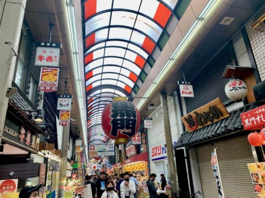 2. Kuromon Ichiba Market covered arcade in Namba, Osaka, with food stalls and the giant red lantern.