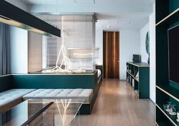 Designer room with teal banquette seating, sculptural pendant light and partition wall at All Day Place Shibuya