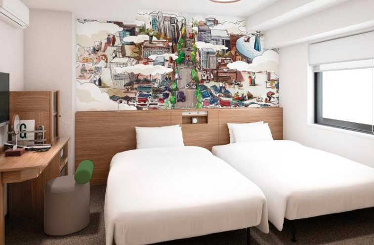 Twin bedroom with white linens, wooden furnishings and distinctive urban mural spanning the wall above headboards. Small desk and window present
