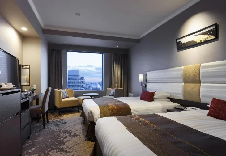 Twin room with two single beds, armchairs and city view at Shibuya Excel Hotel Tokyu