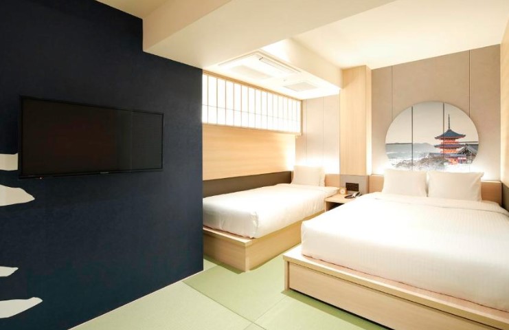 Japanese-style room with tatami flooring, twin beds, navy feature wall and temple artwork