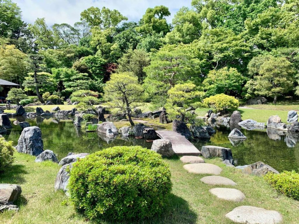 Traditional Japanese garden with stone pond, stepping stones and manicured landscapes