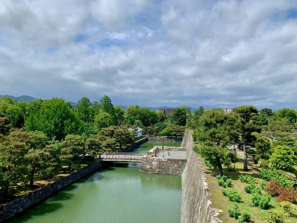Nijo Castle's stone fortifications and moat surrounded by gardens,