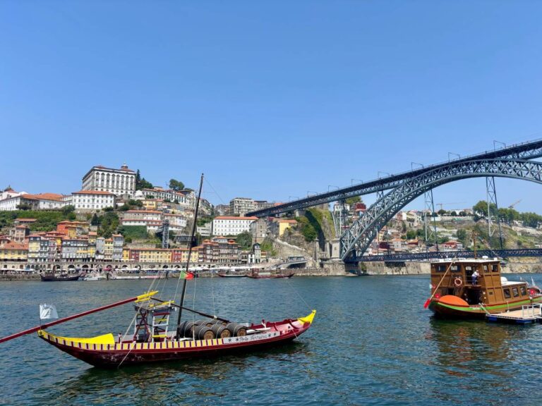 Traditional rabelo boats on Douro River with Dom Luís I Bridge, iconic Porto landmarks perfect for sightseeing itineraries
