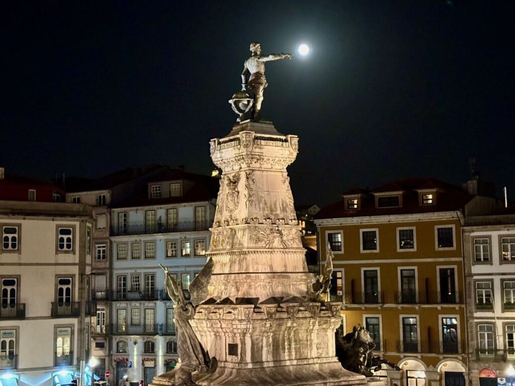 Illuminated Dom Pedro IV monument at night in Rossio Square, central Porto landmark perfect for evening strolls during your visit