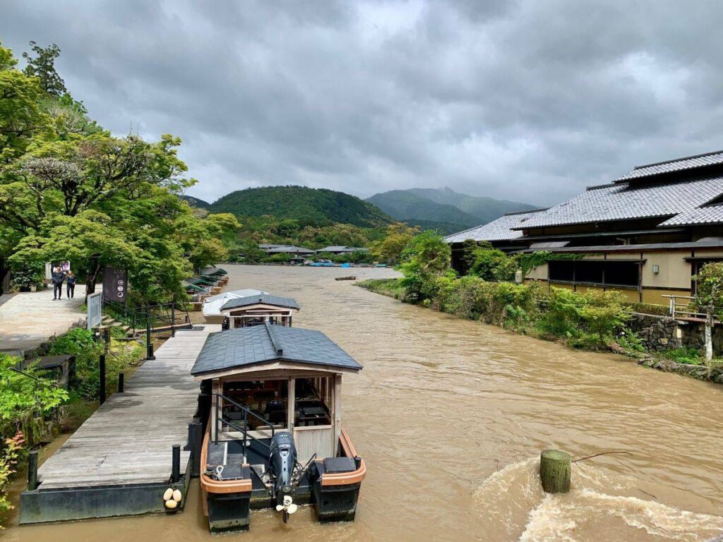 Hozu River boat dock in Arashiyama with muddy waters and mountains