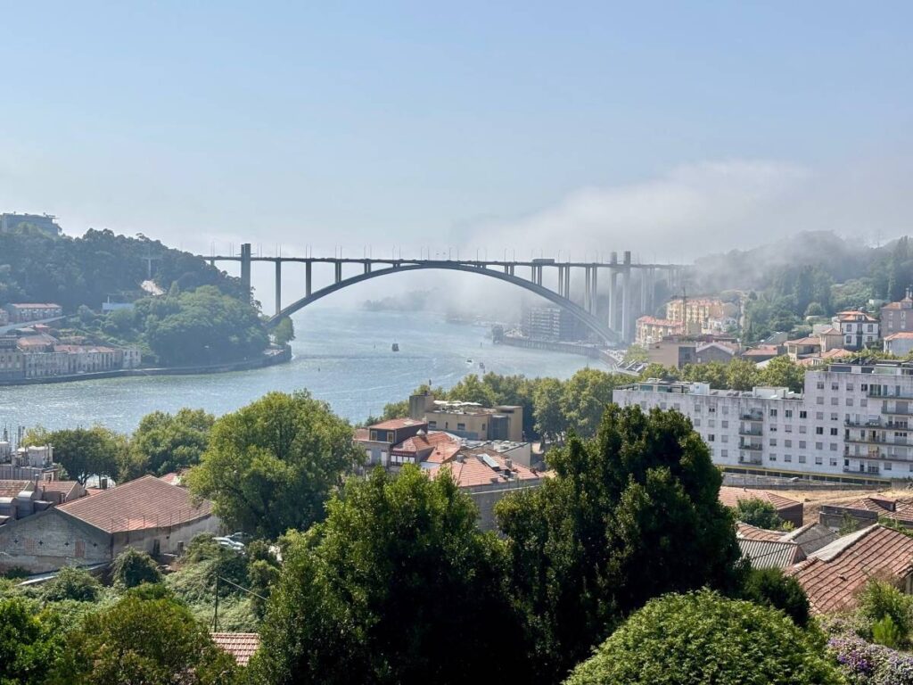 Arrabida Bridge spanning Douro River with residential Porto districts below, major transport link connecting the city areas