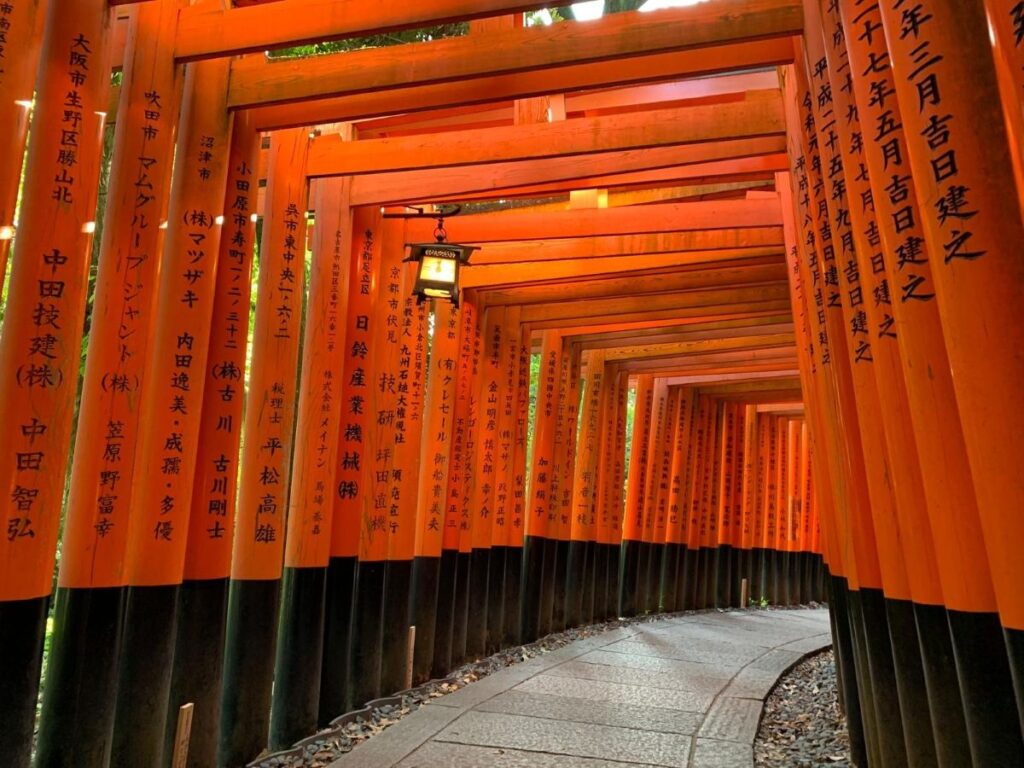 Fushimi Inari's famous thousand vermillion torii tunnel with inscribed donor names, Kyoto's most photographed shrine pathway