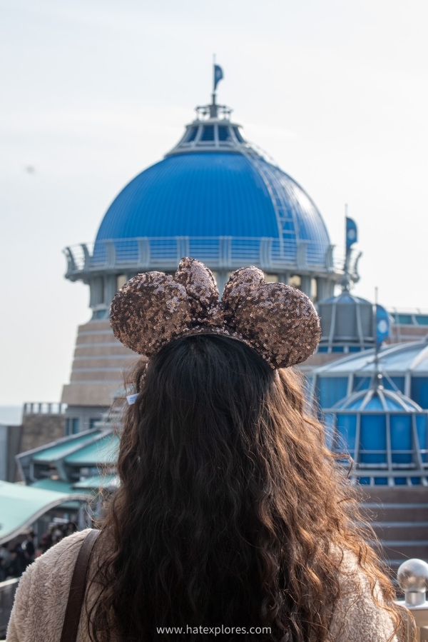 Visitor wearing sequined mouse ears facing the Arabian Coast dome at Tokyo DisneySea.