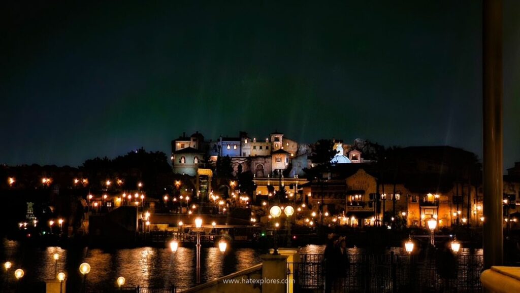 Night view of Tokyo DisneySea with illuminated Mediterranean Harbor buildings reflecting on the water