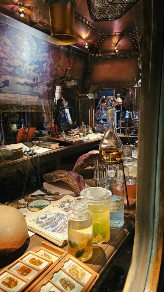 Laboratory-style setting with glass bottles, books, and scientific equipment in a themed attraction.