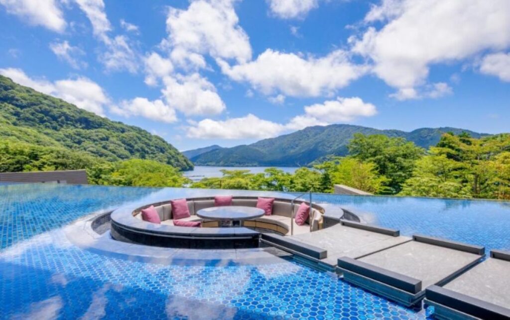 Infinity pool with circular seating area overlooking Lake Ashi and mountains in Hakone