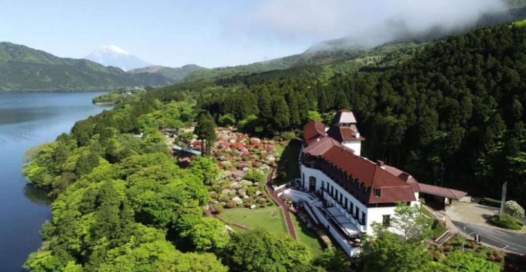 Aerial view of lakeside ryokan with Mount Fuji in background, Hakone hot spring region