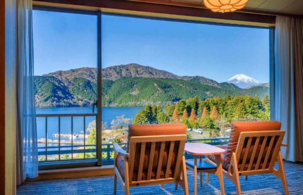 Ryokan room seating area with panoramic views of Lake Ashi and Mount Fuji