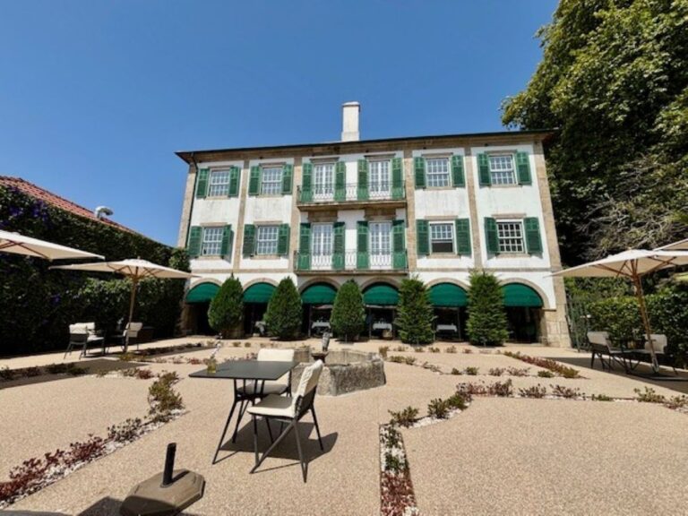 Stone manor house with green shutters, arched terraces and formal garden courtyard