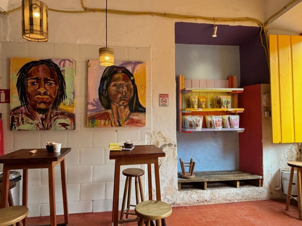 Rustic café interior with portrait paintings, wooden furniture and woven pendant lights