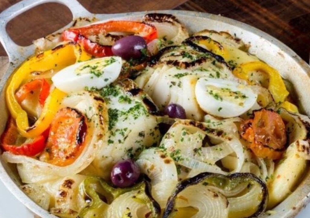 Baked pasta dish with grilled vegetables, boiled eggs and black olives on flatbread