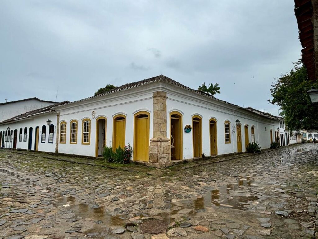 Portuguese colonial corner building with yellow doors and cobblestone street