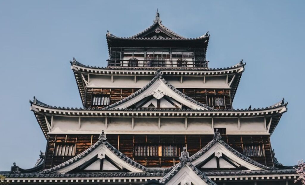 Traditional five-storey Japanese castle with curved tiled roofs and white walls
