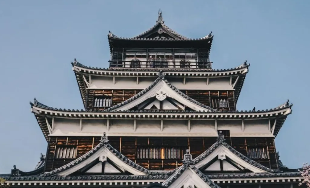 Traditional five-storey Japanese castle with curved tiled roofs and white walls