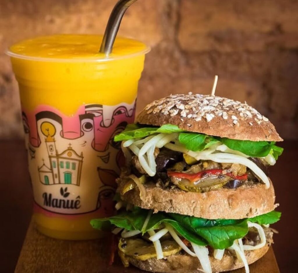 Seeded multigrain burger filled with vegetables and cheese served with mango smoothie