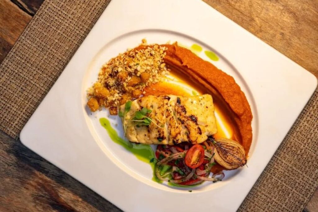 Plated fish fillet with crumb topping, sweet potato purée and caramelised onion