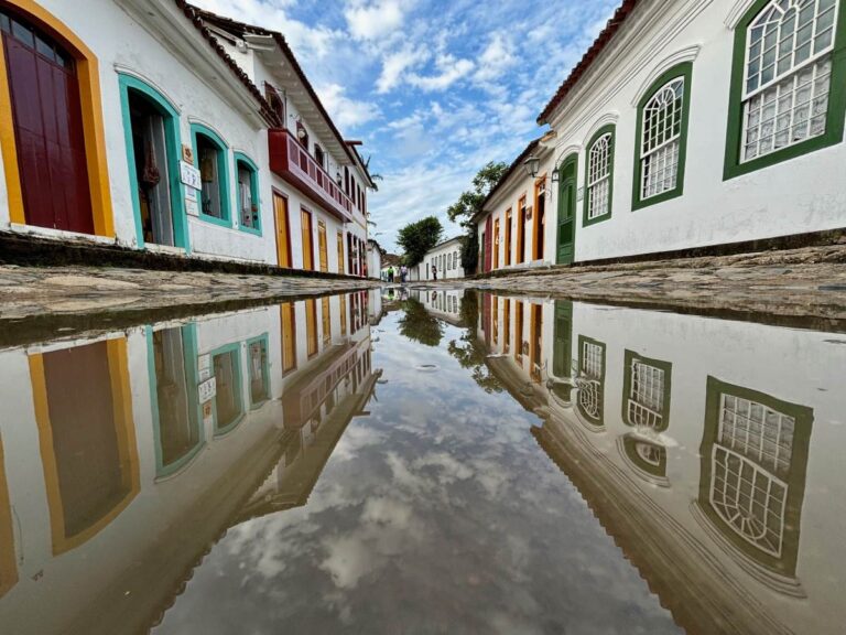Historic street with multicoloured doors and windows reflected in puddle