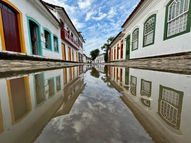 Historic street with multicoloured doors and windows reflected in puddle