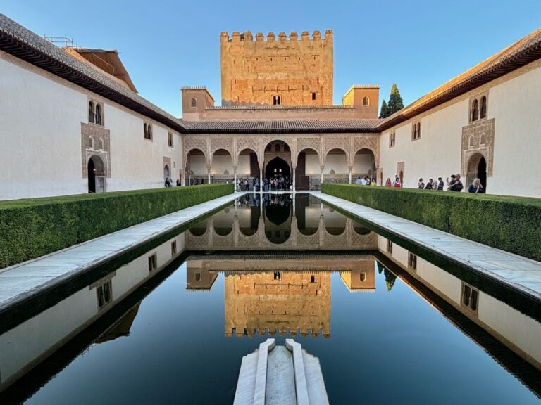 Court of the Myrtles at the Alhambra with tower and arches mirrored in the still central pool.