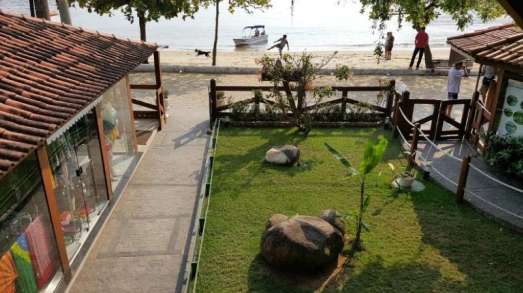 Beachfront courtyard with lawn leading directly to sandy beach and calm waters