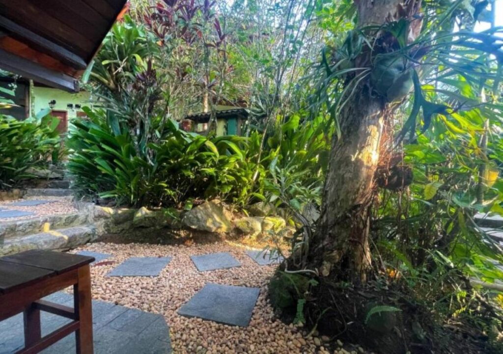Tropical garden pathway with stepping stones, pebbles and lush vegetation at Brazilian guesthouse