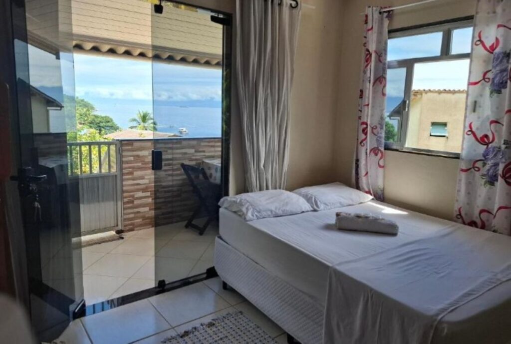 Simple guest room with double bed, balcony access and mountain views