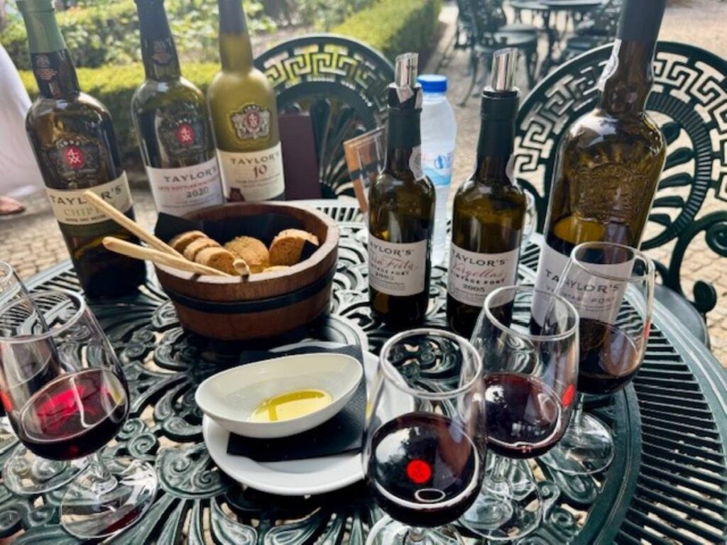 Port wine tasting setup with multiple bottles, glasses and olive oil on decorative tray