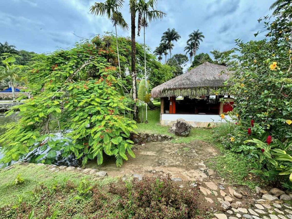 Thatched-roof beach kiosk surrounded by tropical gardens and palm trees