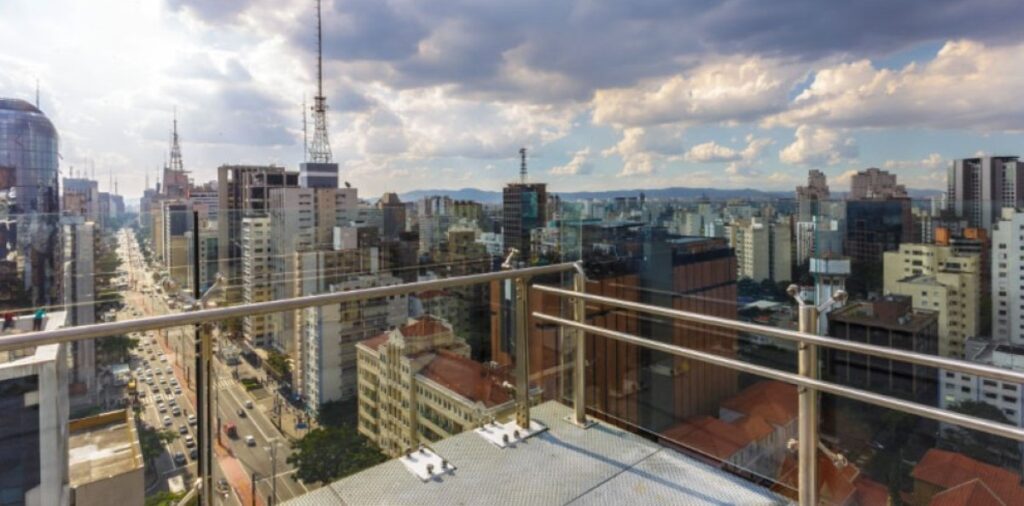 View from a Sesc rooftop terrace over the city skyline and high-rises under dramatic clouds