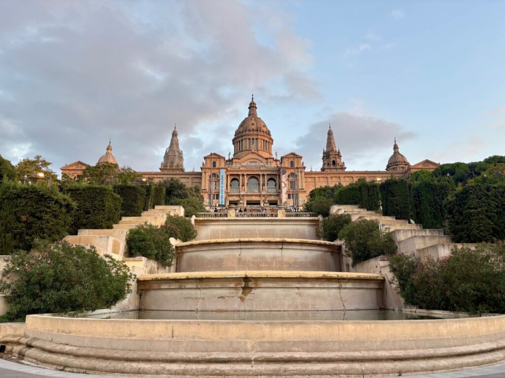 Museu Nacional d’Art de Catalunya seen from the terraces, with grand steps and domed roof at dusk.
