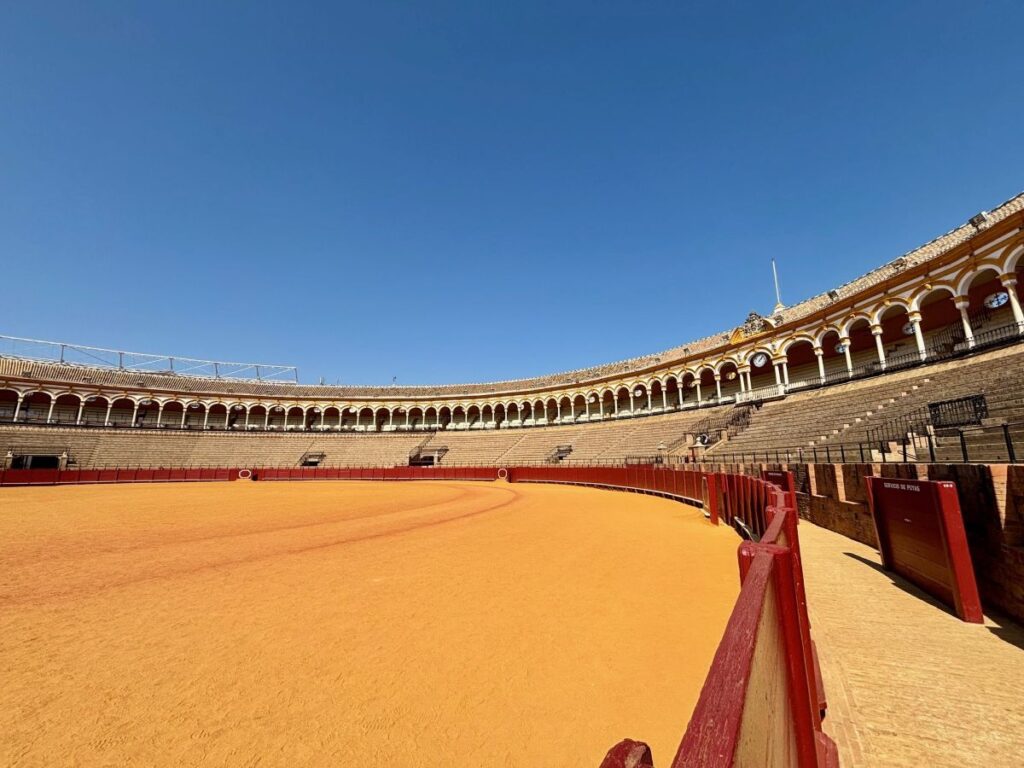 Plaza de Toros de la Maestranza bullring arena, wide view of the sand ring and tiered stands.