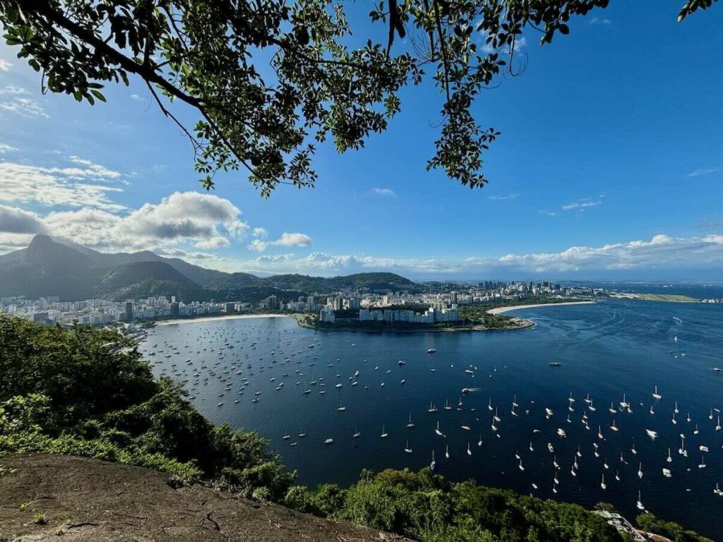 Botafogo Bay viewed from Urca Hill, sailboats anchored in blue water, Corcovado and Christ the Redeemer in the distance