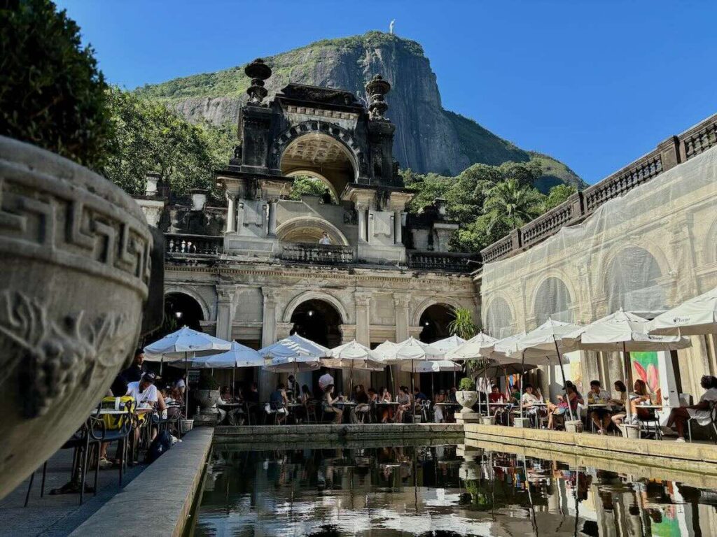 Parque Lage courtyard café, white umbrellas and reflecting pool with Corcovado mountain and Christ the Redeemer behind
