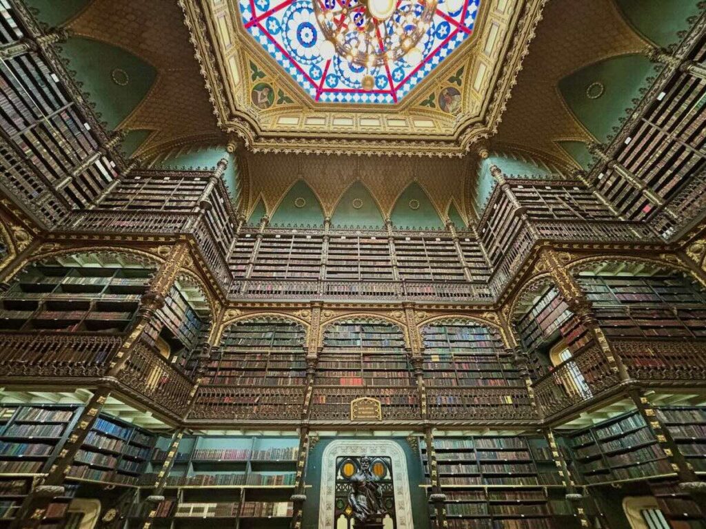 Real Gabinete Português de Leitura, ornate carved wood bookshelves on three storeys and a stained-glass ceiling chandelier