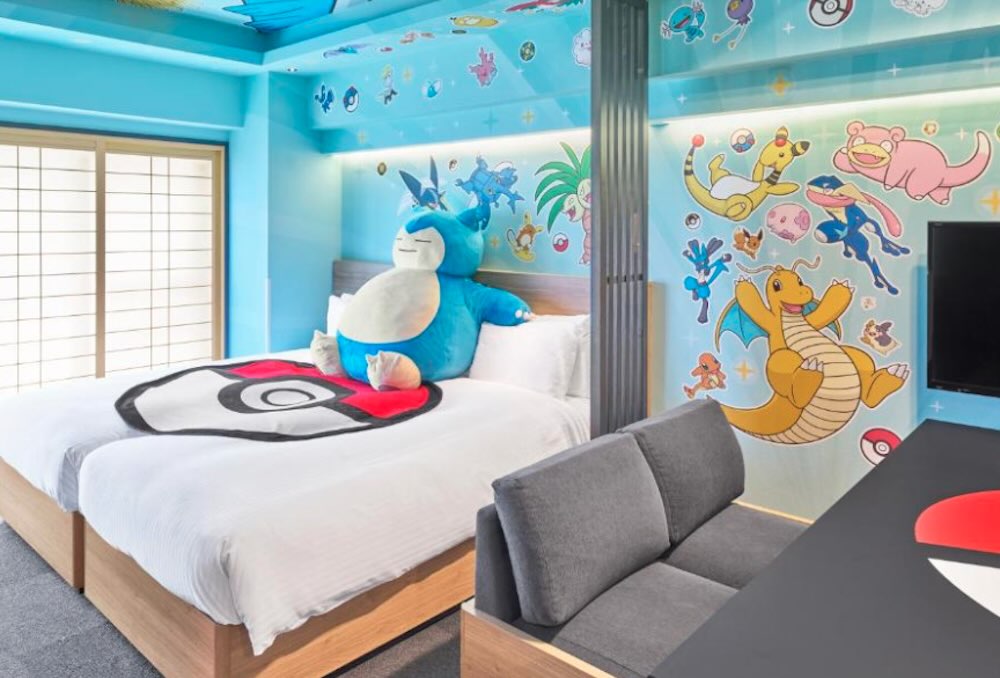 Pokemon-themed family room with a giant Snorlax plush on the bed, character wall decals and a Poke Ball blanket