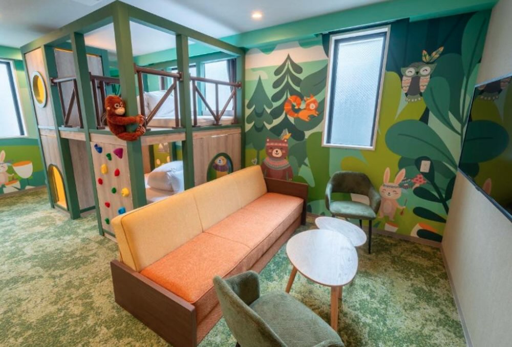 Kids' jungle-themed family room with a bunk-bed den, climbing wall, woodland wall mural and a bright orange sofa