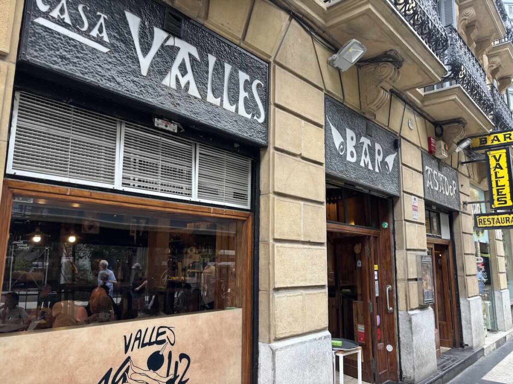 Exterior of Casa Vallés bar and asador, with black lettering and a gilda logo painted below the window