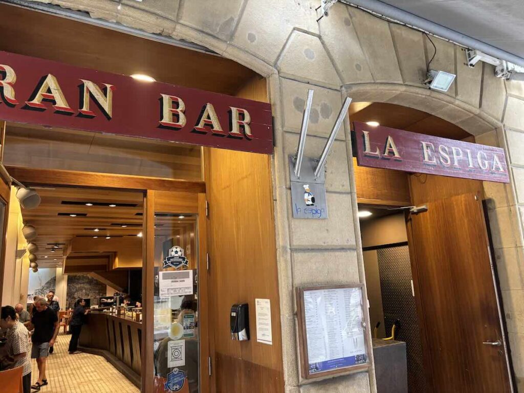 Twin entrances to Gran Bar and La Espiga, with a printed menu framed beside the door